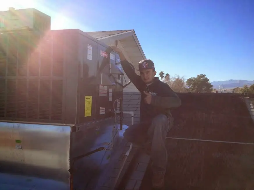 HVAC technician performing Heat Pump Repair on a rooftop unit in Ventnor City