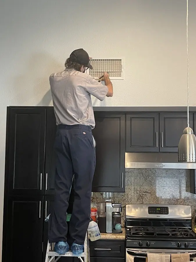 Technician inspecting an air vent during HVAC service in Ventnor City